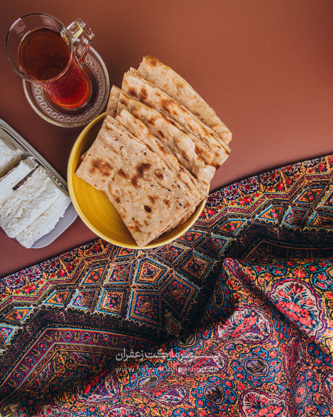 Lavash, Tee und Käse auf einem persischen Teppich von oben